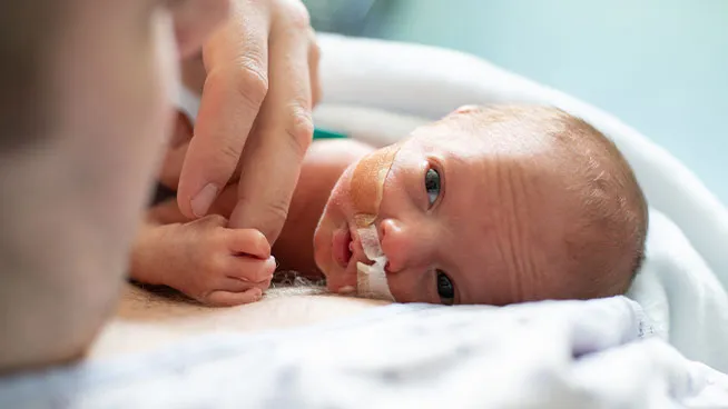 Bebé prematuro sosteniendo el dedo de mamá