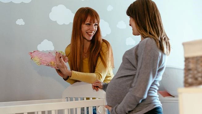 Expecting mom and doula talking in baby's nursery