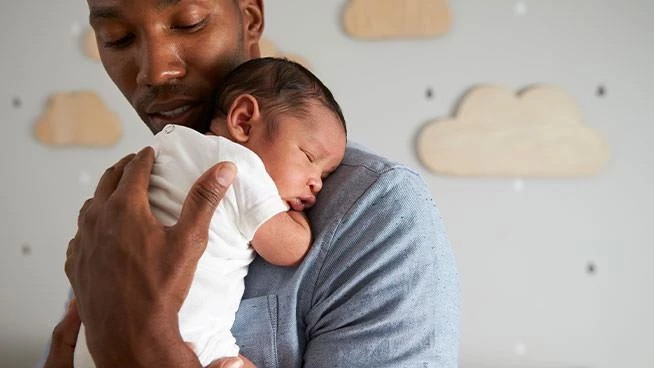Dad holding baby in nursery
