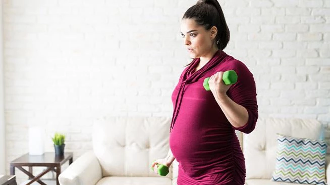 Pregnant woman lifting light weights