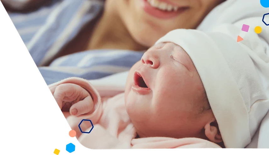 Newborn baby being held by smiling mom