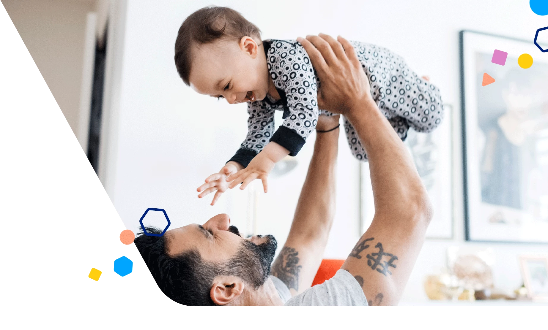 Papá sonriente levantando a su bebé feliz en el aire