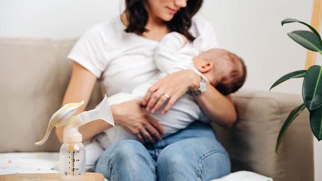 Breast pump on the table in front of mom and baby