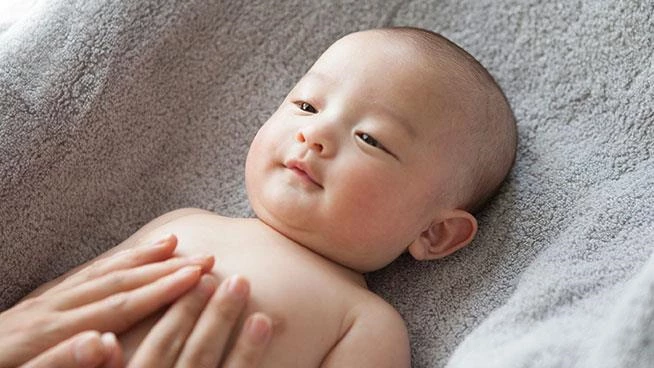 Parent massaging baby's tummy