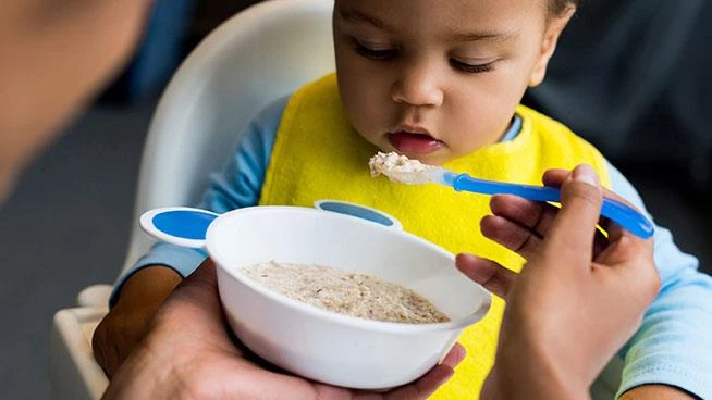 Alimentar al niño pequeño con una cucharada de comida