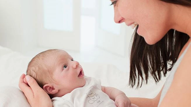 Mom holding 2 month old baby