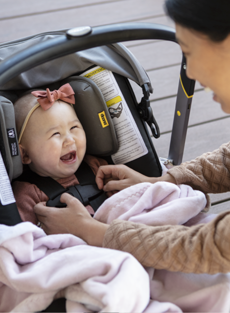 Baby in carseat smiling at mom