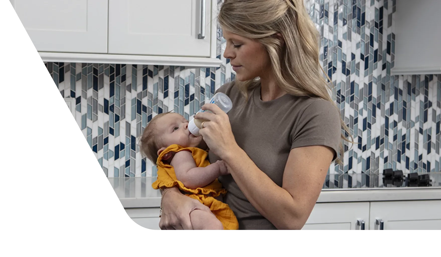 A woman holding a baby while baby drinks from a bottle