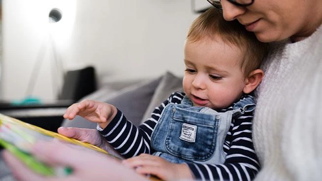 Mom looking at picture book with toddler