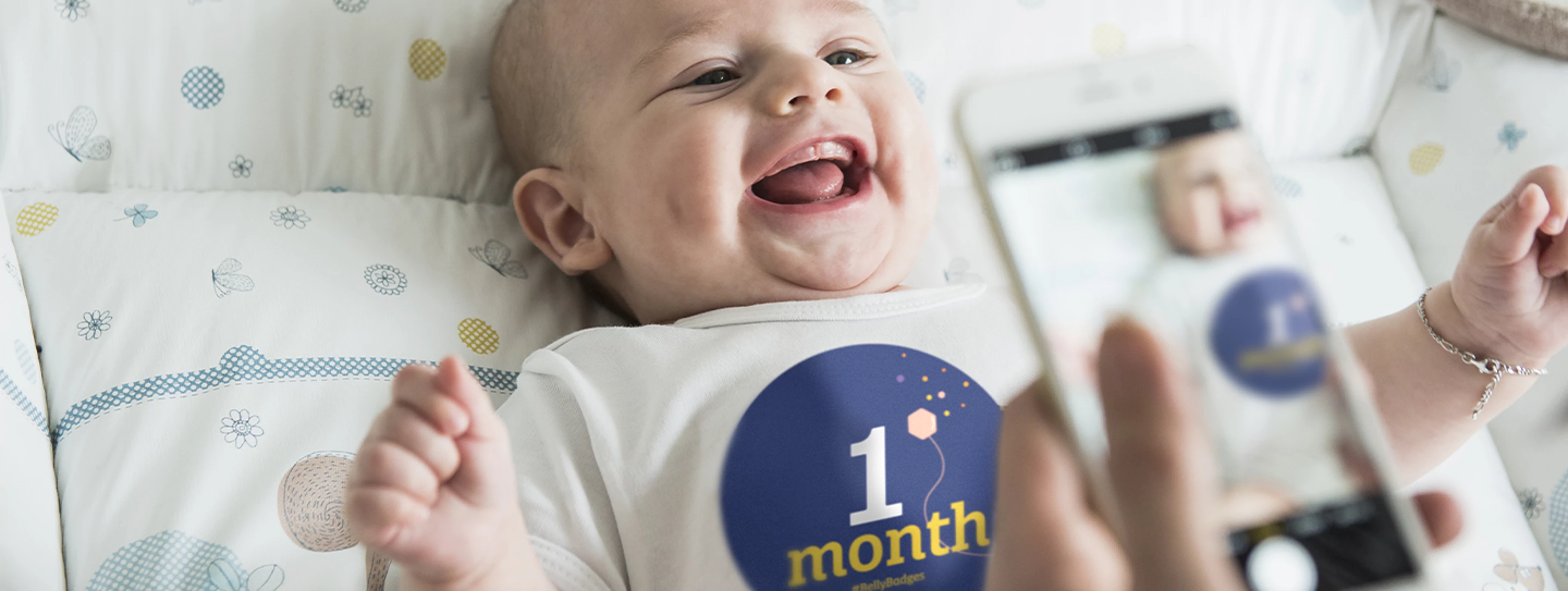 Happy baby wearing an Enfamil BellyBadge™