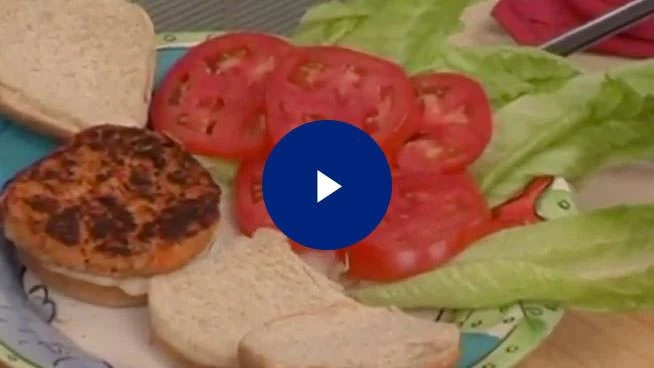 Close up of salmon burgers, buns, lettuce, and tomatoes