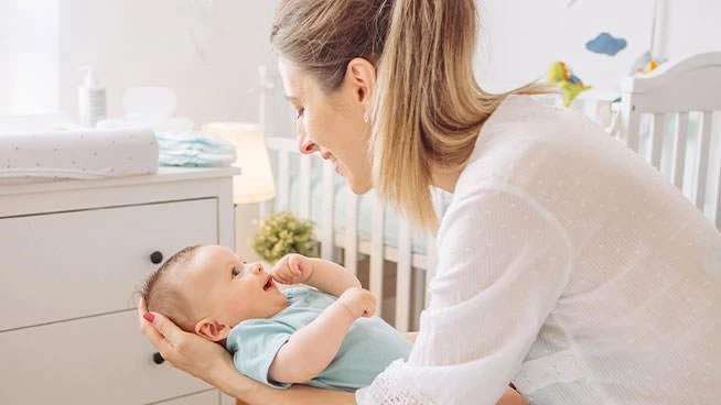 Mom holding baby in nursery