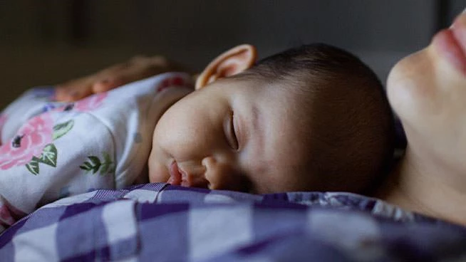 Mom holding infant at night