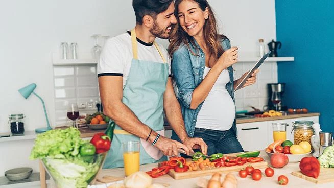 Pregnant wife and husband cooking together