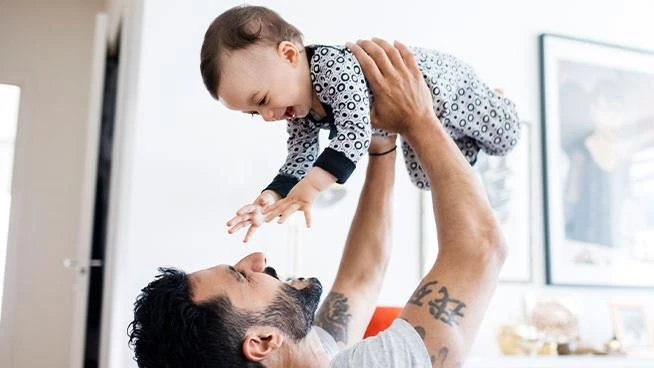 Dad lifting infant son in the air