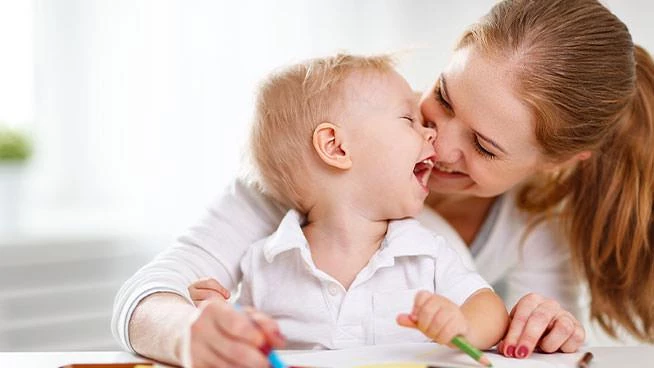 Mom and toddler son coloring with coloring pencils