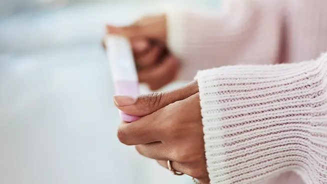Woman holding pregnancy test