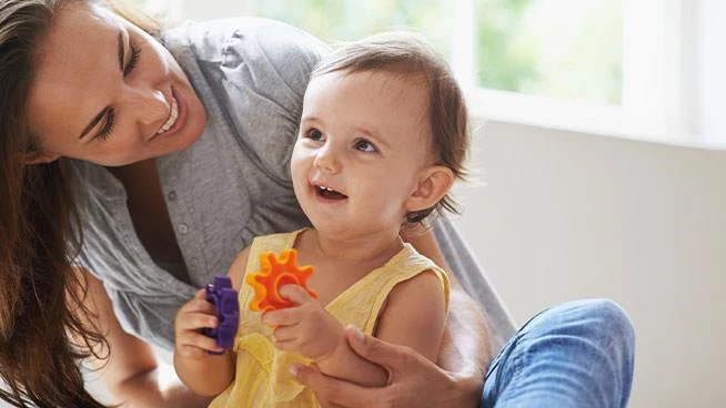 Mom and toddler playing with gear toys