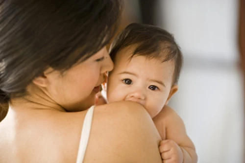 Baby peeking over mom's shoulder