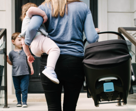 Mom carrying child and carseat