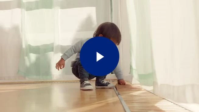 Image of toddler crouching down with play button overlay