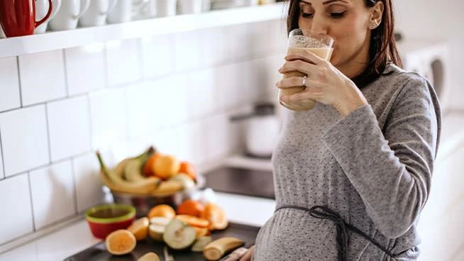 Pregnant mom drinking a smoothie