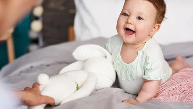 Baby smiling with stuffed bunny