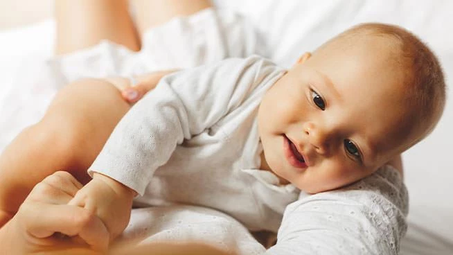 Smiling baby laying on moms chest
