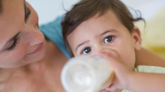  Mamá felizmente mirando al bebé que está bebiendo un biberón