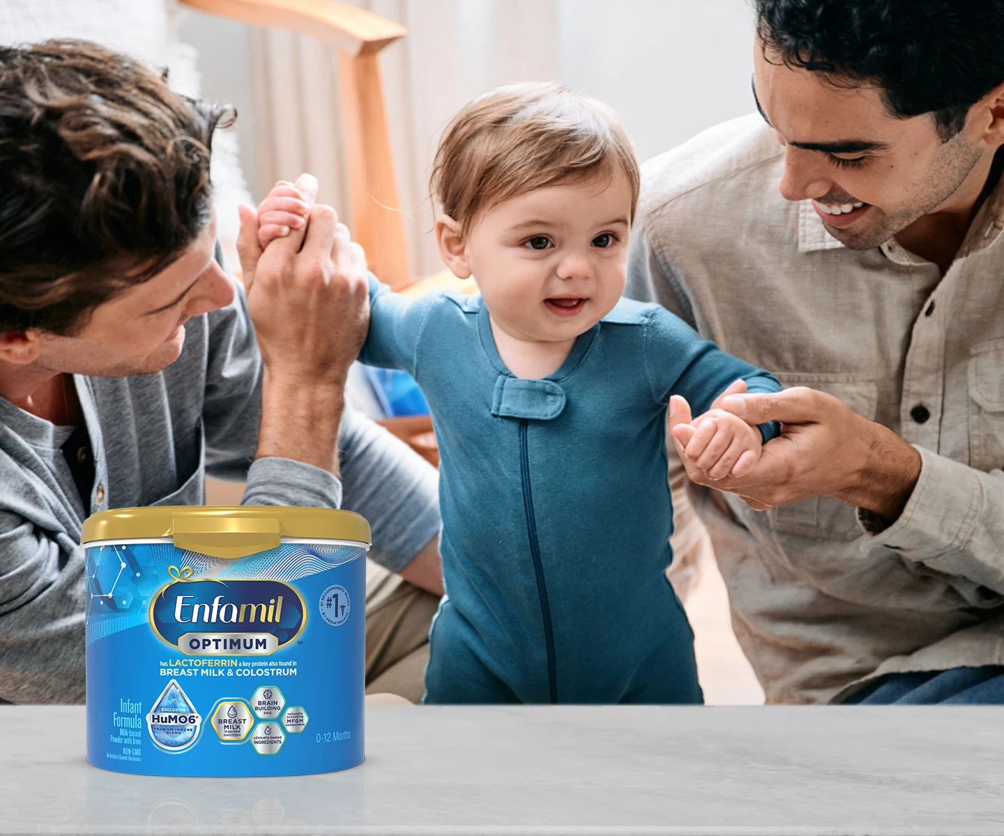 Two dads helping baby walk with Enfamil Optimum tub
