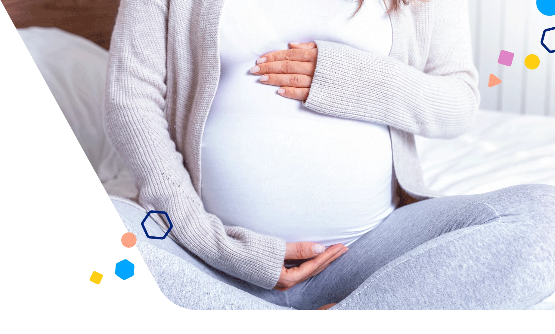 Mamá embarazada sentada con las piernas cruzadas sosteniendo su vientre