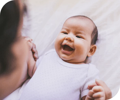 Bebé riendo tomados de la mano con mamá