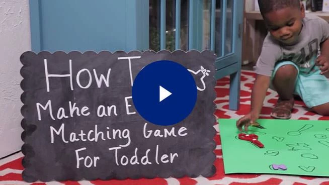 Toddler playing matching game with play button overlay