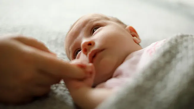 Newborn holding mom's finger