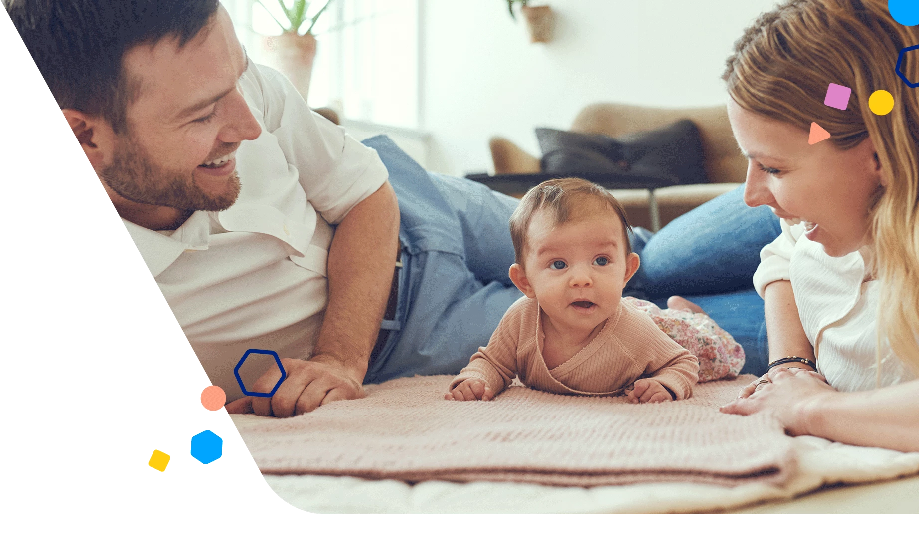 Mamá y papá jugando en el suelo con su bebé