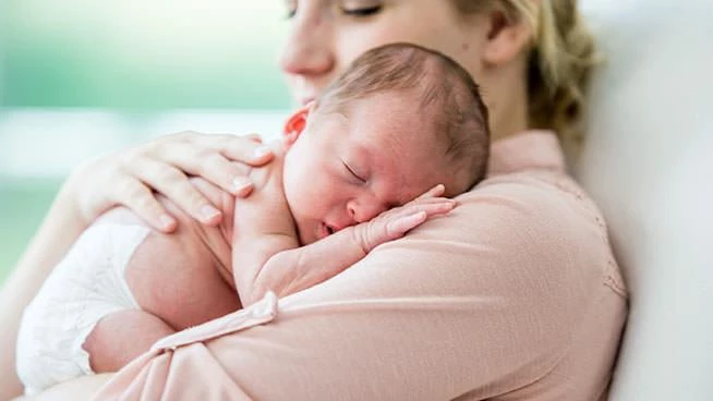 Mom snuggling newborn baby