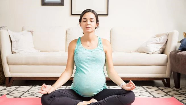 Pregnant mom doing yoga in her living room