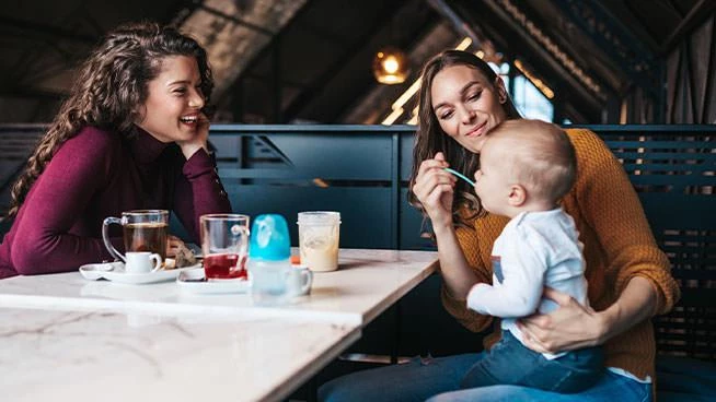 Mom and friend eating with a toddler at a restaurant