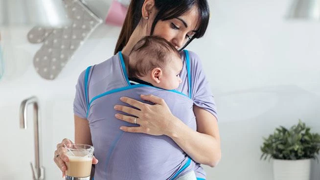 Mom holding infant in a baby carrier