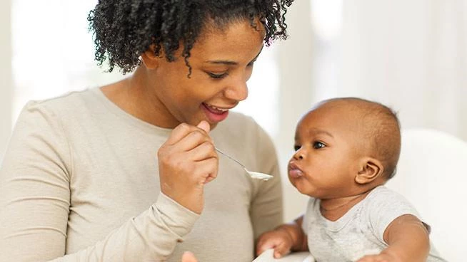 Mom spoon feeding baby