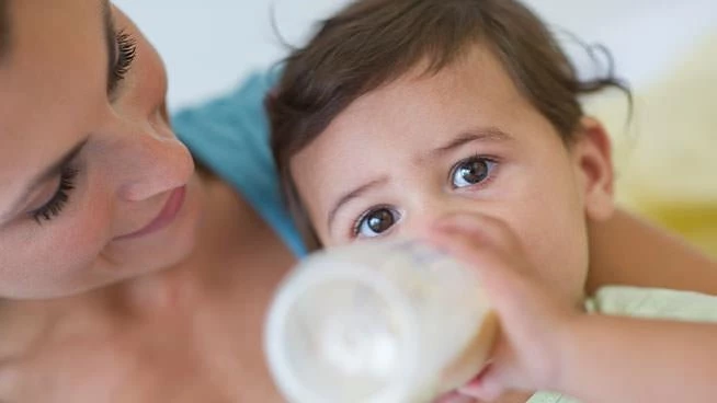 Mom holding baby drinking from bottle