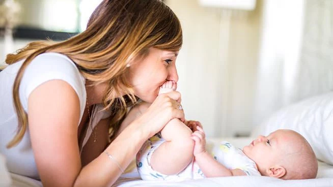 Mom kissing baby's feet