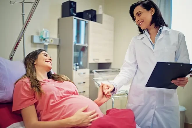 Doctor holding pregnant woman's hand