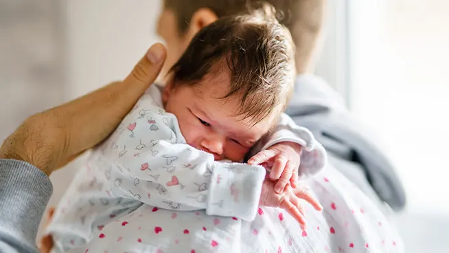Dad comforting newborn