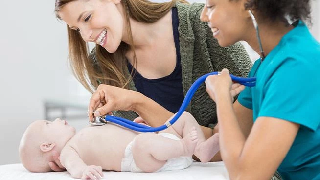 Mom and nurse smiling at baby in pediatrician's office