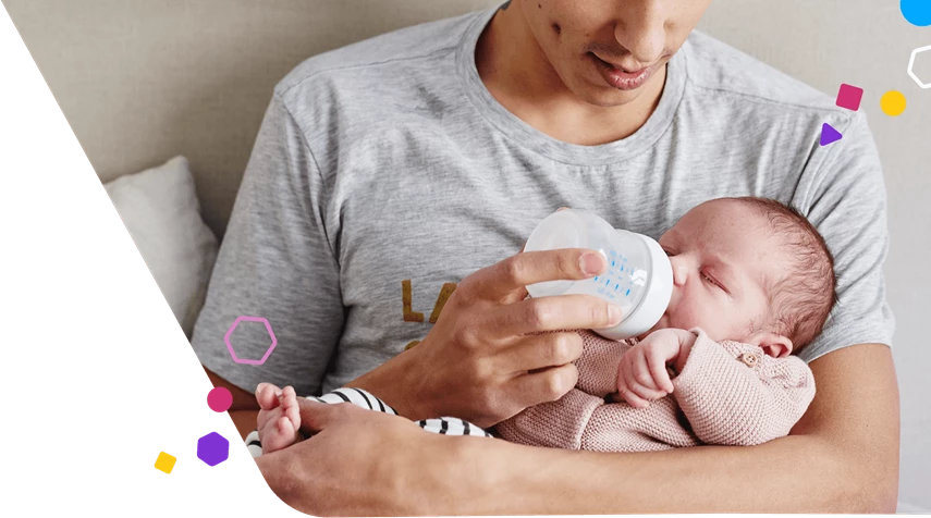 Papá sosteniendo al bebé y dándole el biberón