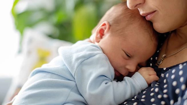 Mom holding newborn close