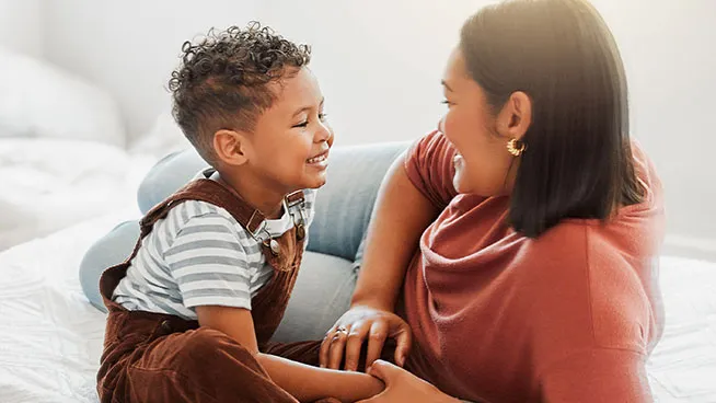 Mom and son sitting on floor talking to each other